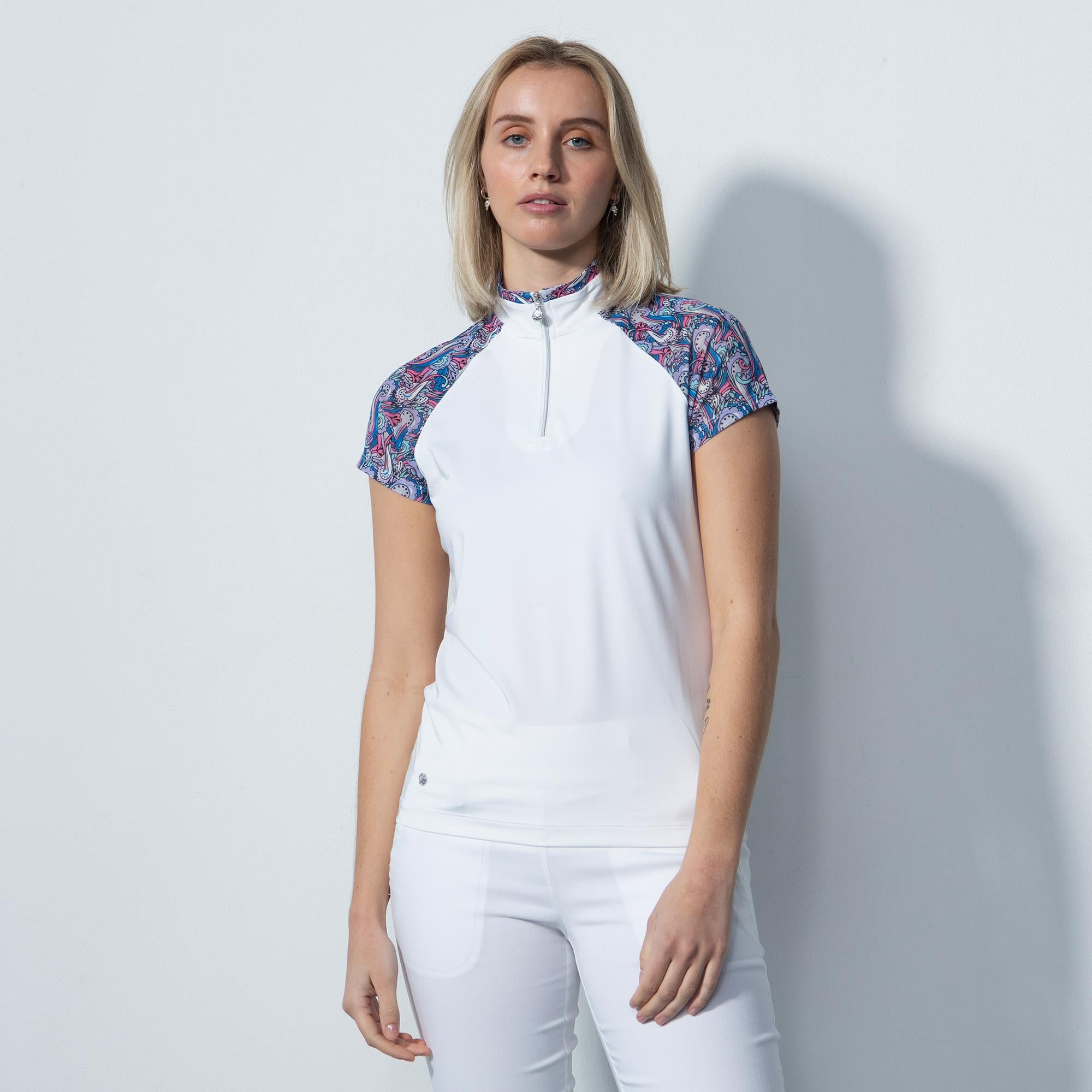 blonde model shot wearing white polo shirt with shoulder detail and white trousers